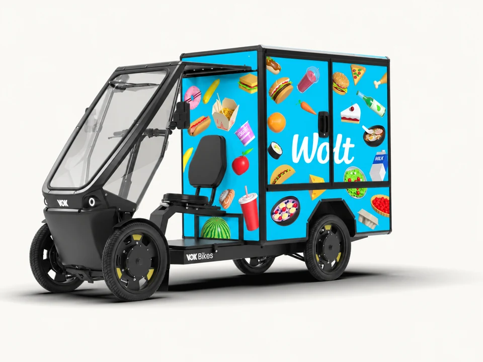 Vok XL with an illustrative Wolt-blue advertising wrap and FleetX operator mark